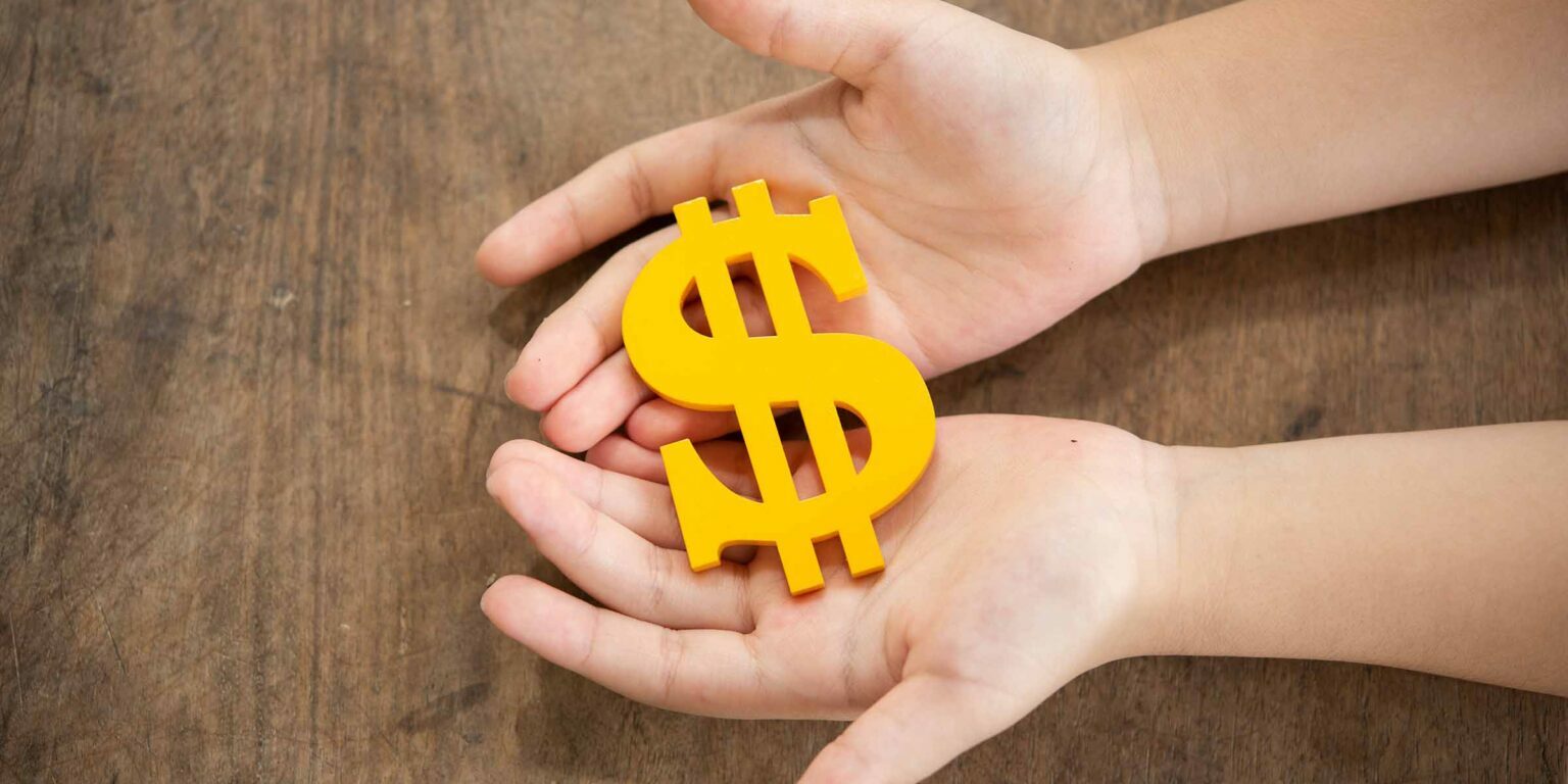 The yellow dollar symbol on hands child for the investment or saving of people with differences diversity for insurance, education, safety life for good and stable in future of family